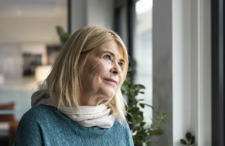 Kvinne ser ut av vindu