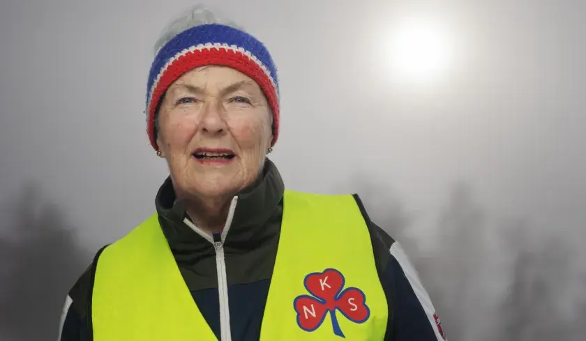 Sanitetskvinne med gull vest med kløver