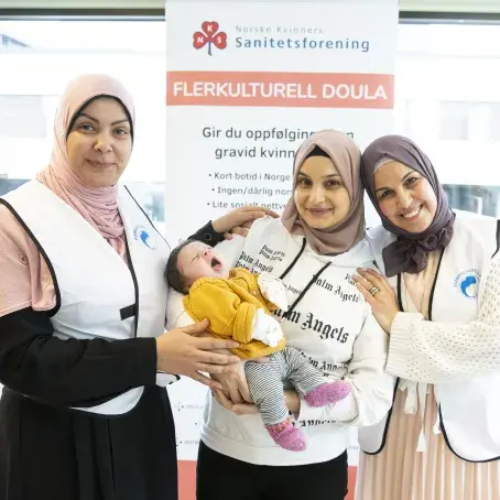 to flerkulturelle doula sammen med nybakt mor og baby